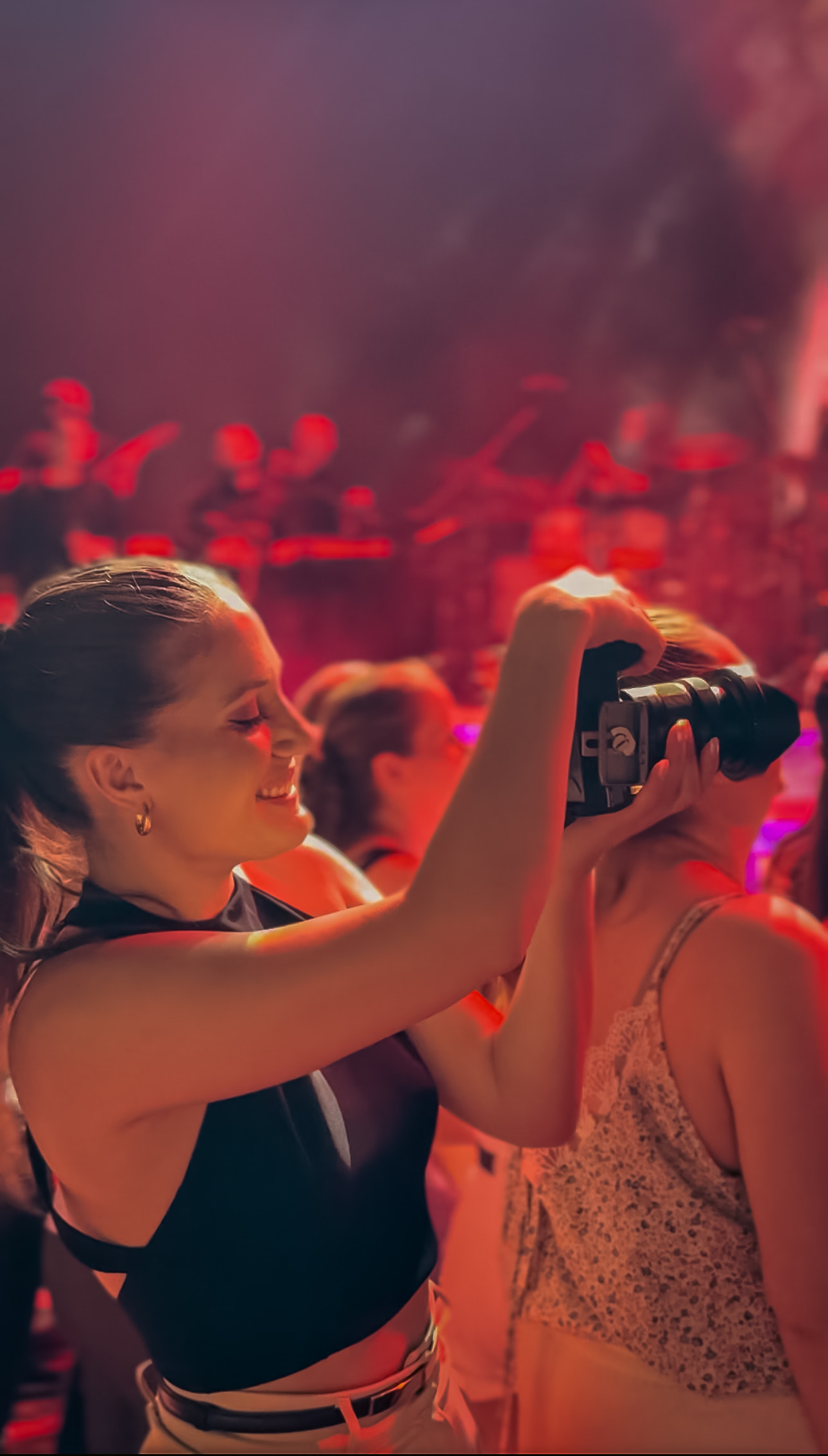 photograph of the videographer in a club with a camera filming footage for it